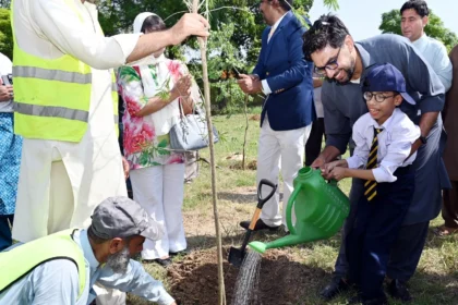 Participants planting a tree during EWCA Islamabad Chapter plantation drive at IIUI