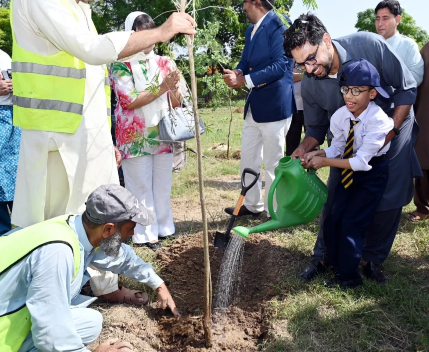 Participants planting a tree during EWCA Islamabad Chapter plantation drive at IIUI