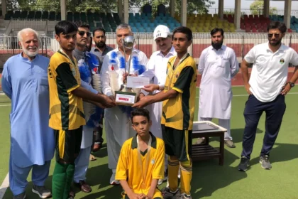 Chamkani team receiving Peshawar Inter-School Hockey Tournament trophy